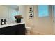 Well-lit powder room featuring dark cabinets, modern fixtures, and neutral decor at 12428 Lincoln Creek Ave, Las Vegas, NV 89138