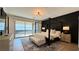 Stylish bedroom featuring a four-poster bed, dark accent wall, and outdoor access at 12428 Lincoln Creek Ave, Las Vegas, NV 89138