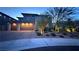 Contemporary home at dusk with a three-car garage and manicured landscaping at 12428 Lincoln Creek Ave, Las Vegas, NV 89138