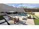 Serene pool area with stylish outdoor seating, a modern fire pit, and lush landscaping, perfect for relaxation at 12428 Lincoln Creek Ave, Las Vegas, NV 89138