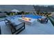Elegant pool area featuring a fire pit, comfortable seating, and lush landscaping, creating a relaxing outdoor space at 12428 Lincoln Creek Ave, Las Vegas, NV 89138