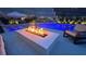 Backyard poolside view of the fire pit with the swimming pool and seating at 12428 Lincoln Creek Ave, Las Vegas, NV 89138