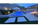 Backyard swimming pool with lights, lounge chairs, umbrella and a fire pit at 12428 Lincoln Creek Ave, Las Vegas, NV 89138