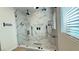 This luxurious frameless glass shower features dual shower heads and marble accents throughout at 12428 Lincoln Creek Ave, Las Vegas, NV 89138