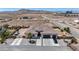 An aerial view of a desert landscape with a white home featuring an attached garage and desert landscaping at 12720 Davis Wright Ct, Henderson, NV 89044