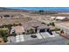 Aerial view of a white home with an attached garage, surrounded by desert landscape and block wall at 12720 Davis Wright Ct, Henderson, NV 89044