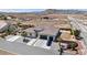 An aerial view of desert landscape with a home featuring a tile roof and three-car garage at 12720 Davis Wright Ct, Henderson, NV 89044