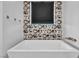 A modern tub sits in front of a decorative wall in this bathroom at 12720 Davis Wright Ct, Henderson, NV 89044