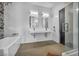 A modern bathroom with double sinks, bathtub, and glass-enclosed shower at 12720 Davis Wright Ct, Henderson, NV 89044