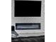 Modern fireplace with a geometric white accent wall and mounted television at 12720 Davis Wright Ct, Henderson, NV 89044