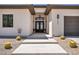 Elegant entryway with decorative iron double doors, desert landscaping, and a covered porch at 12720 Davis Wright Ct, Henderson, NV 89044