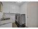 Laundry room with modern appliances, white cabinets, and a sleek countertop at 12720 Davis Wright Ct, Henderson, NV 89044