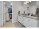 Bathroom with dual granite sinks and white cabinetry, with a walk in closet at 1581 Cavalry St, Pahrump, NV 89048