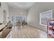 Dining room view featuring hardwood floor, three windows, chandelier, and vaulted ceiling at 1581 Cavalry St, Pahrump, NV 89048