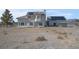 Wide shot of a two story home with solar panels surrounded by large arid backyard at 1581 Cavalry St, Pahrump, NV 89048