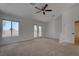 Large carpeted bedroom featuring a ceiling fan, window and access to a private balcony at 1790 Castro Hill Ave, Henderson, NV 89012