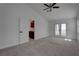 Bright main bedroom with carpet, ceiling fan, and a double door leading to the balcony at 1790 Castro Hill Ave, Henderson, NV 89012