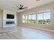 Bright living room featuring a fireplace, ceiling fan, and large windows with stunning golf course views at 2024 Bay Tree Dr, Las Vegas, NV 89134