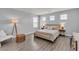 Bright bedroom featuring neutral walls, wood-look floors, a queen bed, and lots of natural light at 2116 Via Firenze, Henderson, NV 89044