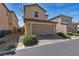 View of a two story house showing the garage, rock landscaping, and a low retaining wall at 2116 Via Firenze, Henderson, NV 89044