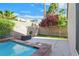 Beautifully landscaped backyard with a pool, vibrant trees, and artificial grass providing a serene outdoor retreat at 2132 Twin Falls Dr, Henderson, NV 89044