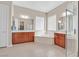 Bright bathroom featuring dual sink vanity, large tub, walk-in shower, and large windows at 2132 Twin Falls Dr, Henderson, NV 89044