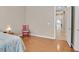 Bright bedroom featuring wood floors, neutral walls, and a glimpse of the kitchen at 2132 Twin Falls Dr, Henderson, NV 89044