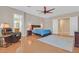 Primary bedroom features wood floors, a ceiling fan and a view to the ensuite bath at 2132 Twin Falls Dr, Henderson, NV 89044