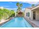 Inviting pool area with a stone surround, flowing waterfall, and lush landscaping, perfect for relaxing and entertaining outdoors at 2132 Twin Falls Dr, Henderson, NV 89044