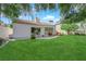 Serene backyard featuring green lawn, patio set, and beautiful landscaping at 240 Windsong Dr, Henderson, NV 89074