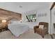 Cozy bedroom with light walls, wood accent wall, comfortable chair, and natural light at 240 Windsong Dr, Henderson, NV 89074