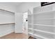Walk-in closet featuring built-in shelving, wood floors, and ample storage space, with access to the bathroom at 240 Windsong Dr, Henderson, NV 89074