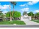 Charming single-story home with a lush green lawn, palm trees, and a two-car garage at 240 Windsong Dr, Henderson, NV 89074