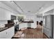 Open kitchen with hardwood floors, white cabinetry, stainless appliances, and lots of natural light at 240 Windsong Dr, Henderson, NV 89074