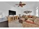 Cozy living room featuring a comfortable sectional sofa, large television, and decorative ceiling fan at 240 Windsong Dr, Henderson, NV 89074