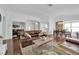 Open living space featuring a brown leather sofa, decorative pillows, and hardwood flooring at 240 Windsong Dr, Henderson, NV 89074