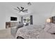 Comfortable main bedroom with ceiling fan, sitting area, backyard view, and a calming interior design at 240 Windsong Dr, Henderson, NV 89074