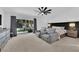 Bright main bedroom featuring large windows with backyard view, seating area, and modern ceiling fan at 240 Windsong Dr, Henderson, NV 89074