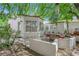 Inviting outdoor patio area with seating, surrounded by lush greenery and mature trees at 240 Windsong Dr, Henderson, NV 89074