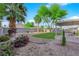 Lush backyard featuring palm trees, manicured bushes and covered patio at 2514 Tropical Sands Ave, North Las Vegas, NV 89031