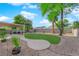 Expansive backyard featuring lush lawn, mature trees, a covered patio, and decorative rock landscaping at 2514 Tropical Sands Ave, North Las Vegas, NV 89031