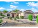 Single-story home with low maintenance desert landscaping with shrubs and trees lining the walkway to the front door at 2514 Tropical Sands Ave, North Las Vegas, NV 89031