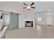 Bright and open living room featuring a fireplace, tile flooring, ceiling fan, and a sliding barn door at 2514 Tropical Sands Ave, North Las Vegas, NV 89031