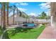 Backyard with a fenced in pool, artificial turf, and mature trees at 2595 Aviv Ct, Las Vegas, NV 89121