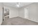 This bedroom has plush carpeting, a ceiling fan, neutral walls, and access to other rooms at 2595 Aviv Ct, Las Vegas, NV 89121