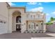 Home featuring a large arched entryway and balcony, white stucco, and an arched window at 2595 Aviv Ct, Las Vegas, NV 89121