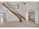 Bright foyer with a curved staircase, iron railing, and large format tile flooring at 2595 Aviv Ct, Las Vegas, NV 89121