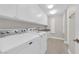 Well-lit laundry room features washer, dryer, sink and ample cabinet space at 2595 Aviv Ct, Las Vegas, NV 89121