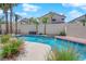 Beautiful backyard pool surrounded by mature palm trees, red flowers and lush greenery at 2595 Aviv Ct, Las Vegas, NV 89121