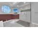 Close-up of stylish shower with marbled tile surround and a stained glass window at 2595 Aviv Ct, Las Vegas, NV 89121